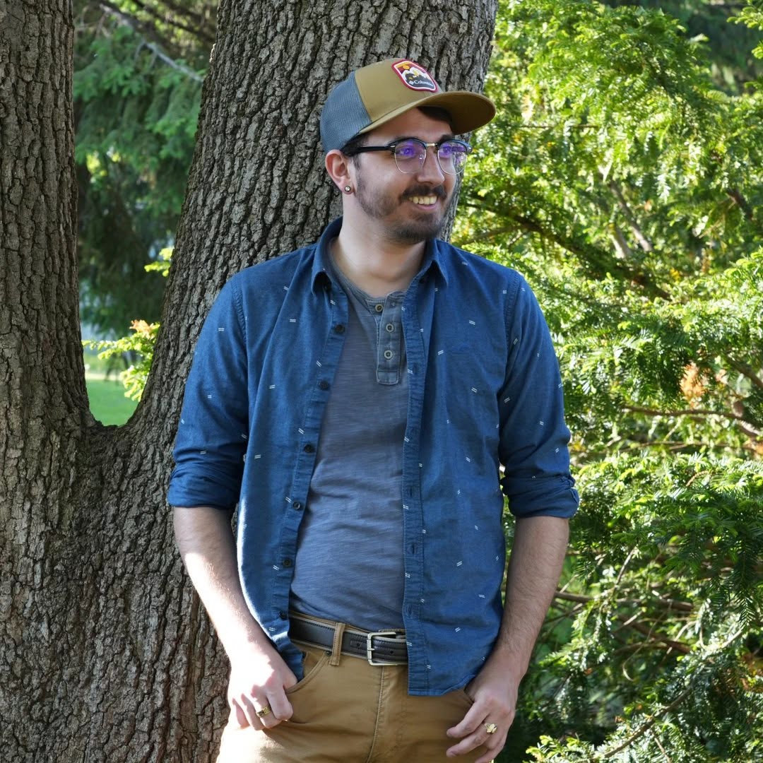 Mitch Reynolds smiling outdoors by a tree